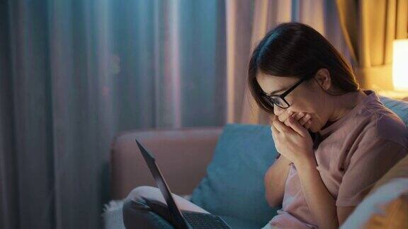 年轻女子在晚上用笔记本电脑和他的男朋友聊天