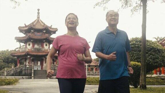 两个活跃的亚洲老年人在公园里动力行走