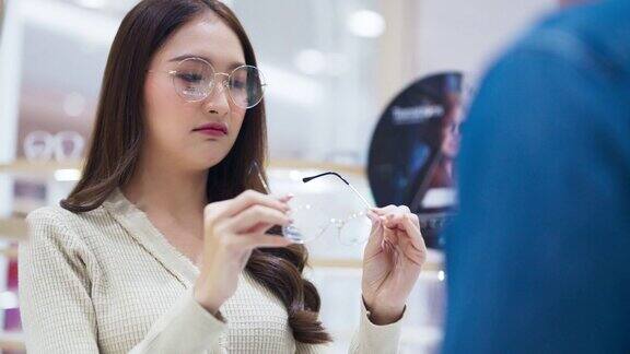 亚洲成年情侣在验光店选购眼镜