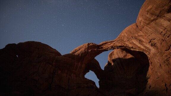 在拱门国家公园的双拱门后面的夜空时间流逝