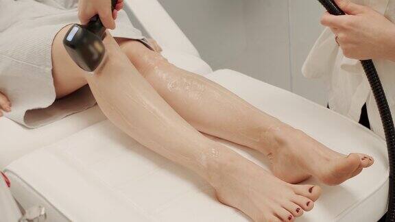 美容师用激光去除美女腿上的毛发