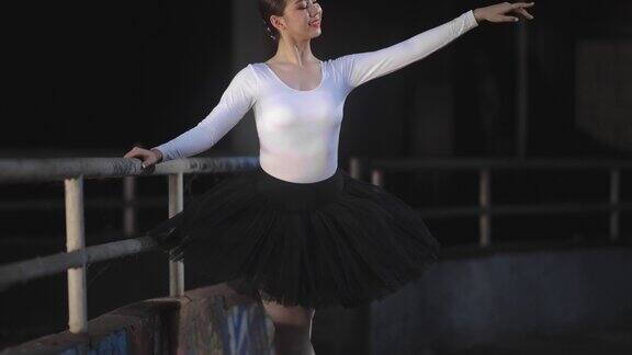 年轻美丽的芭蕾舞女演员在黑暗的大厅里跳舞