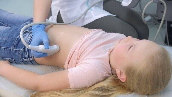 医生正在用扫描仪给小女孩做腹部内部器官超声检查
