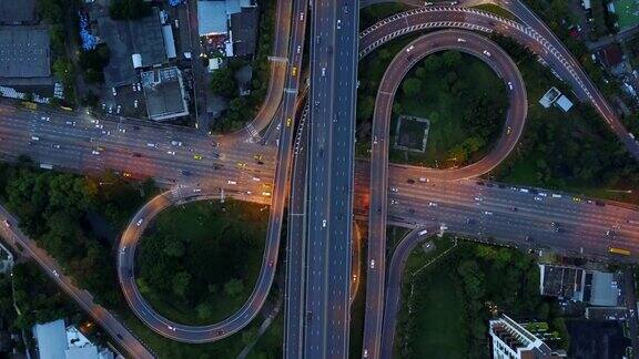 鸟瞰图无限高速公路立交桥与繁忙的城市交通在道路上加速在黄昏