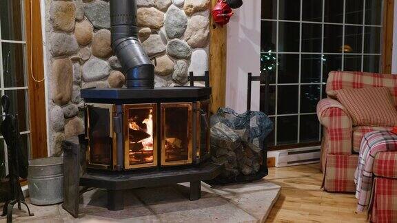 木质火炉壁炉与金属体和玻璃门的房子舒适的内部