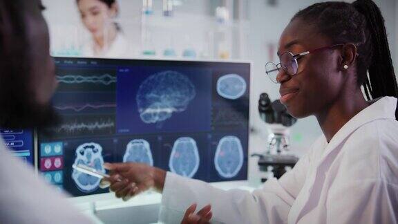 实验室设备和计算机屏幕上的脑电波研究非洲裔科学家讨论
