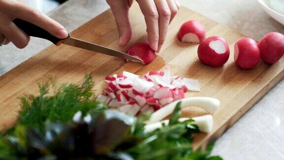 近距离女子用刀在木板上切萝卜概念的蔬菜