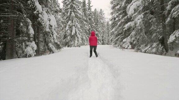 在白雪覆盖的森林里跳跃的女人