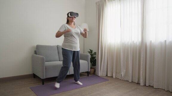 快乐的女人在家里享受虚拟现实运动带着现代科技眼镜在家工作