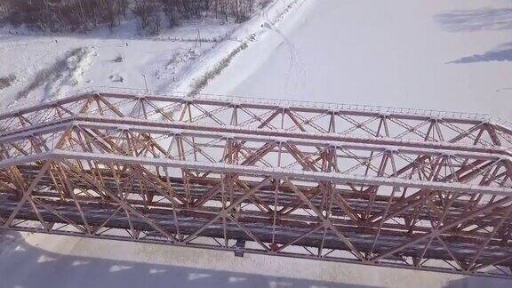 悬索桥用于冬季冰冻河流上的火车运动鸟瞰图火车桥通过冬季河流