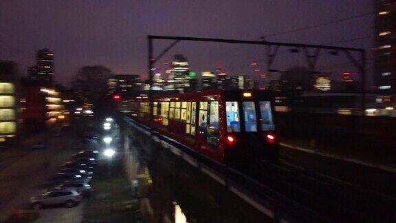 LONDON和夜晚繁忙的通勤火车经过时的