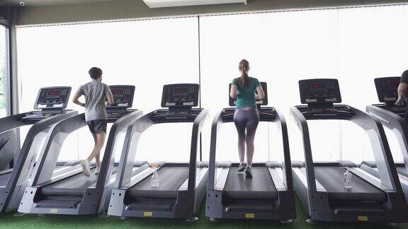 社交距离在健身房的跑步机上跑步