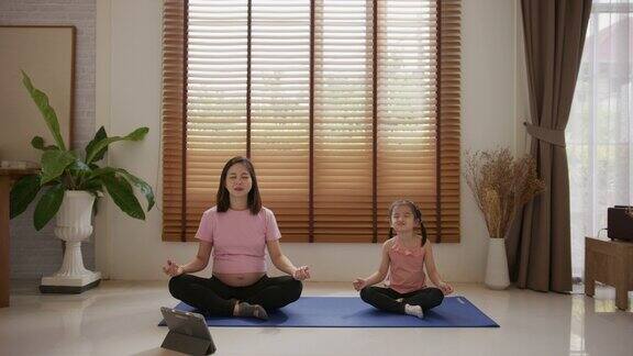 家庭瑜伽概念亚洲母亲在家教小女儿做瑜伽