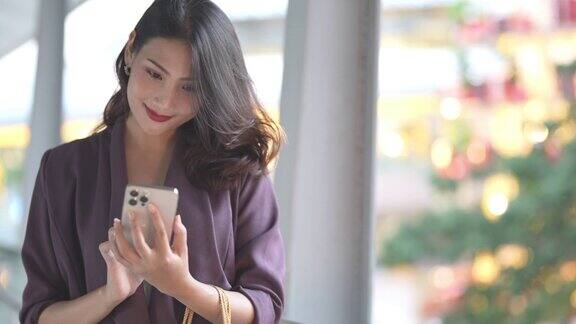亚洲业务的女人一名女性站在城市户外公共空间用智能手机与人交谈