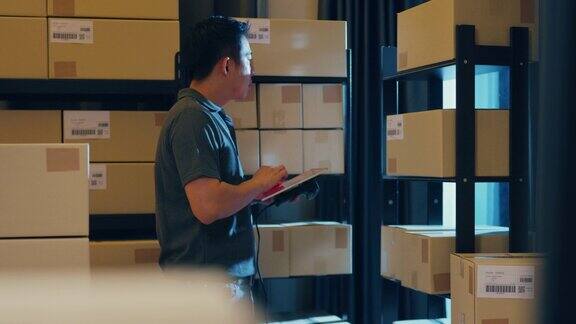 亚洲商人使用条形码扫描仪扫描货架上的纸盒将数据放入数字平板电脑在线切割库存数据信息细节以便在仓库快递