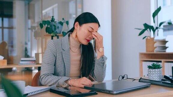 头痛疲劳和困倦的商业女性在笔记本电脑与在线职业压力抑郁和心理健康问题亚洲专业工作者或悲伤的人在办公桌疲劳倦怠和沮丧