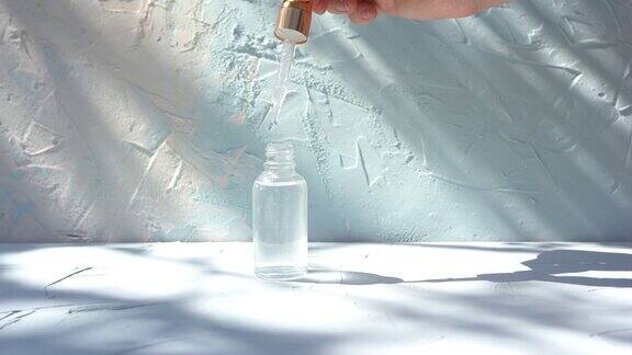 滴管玻璃瓶模型油性液滴从化妆品吸管上落在蓝色背景上