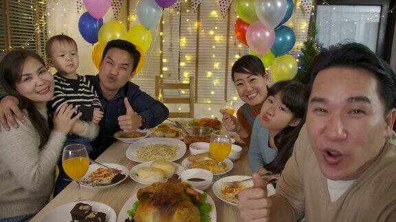 快乐的亚洲家庭在聚会上自拍快乐的朋友在家里一起享受圣诞晚餐