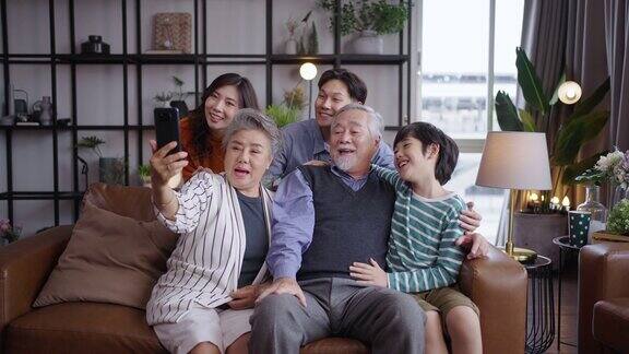 亚洲大家庭在家里对着镜头说话和挥手视频通话在网上聊天交流