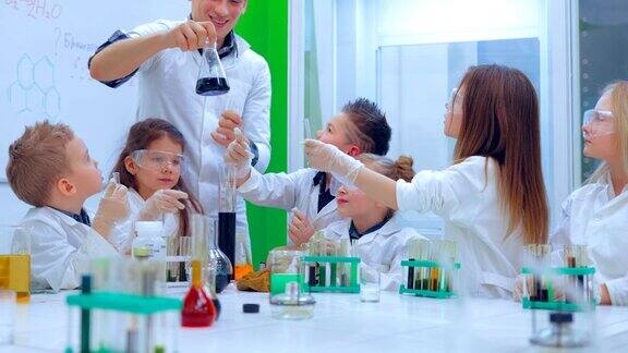 年轻的男孩和女孩们正在做化学实验老师和小朋友在上化学课