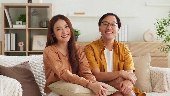 幸福平和随意放松的亚洲已婚夫妇呆在家里良好的亚洲夫妻氛围在家里客厅的沙发沙发上一起聊天温馨的家庭理念