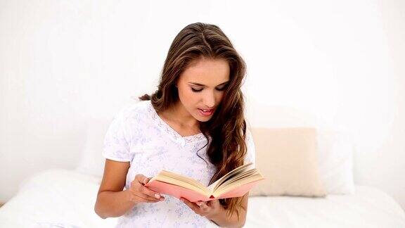 年轻女子在床上看书