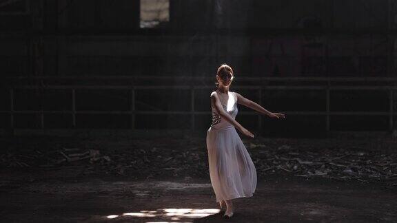 年轻美丽的芭蕾舞女演员在黑暗的大厅里跳舞