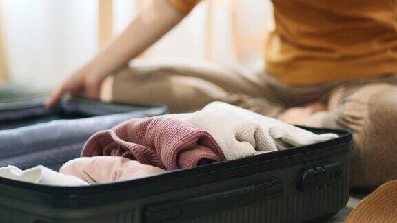 女人把衣服装在行李箱里