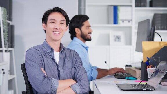 迷人的年轻亚洲商人的肖像微笑在办公室的办公桌工作空间自信的人情绪高兴业务工作者