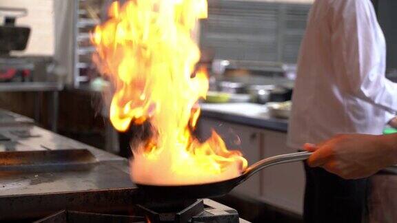 近距离厨师烹饪火在平底锅