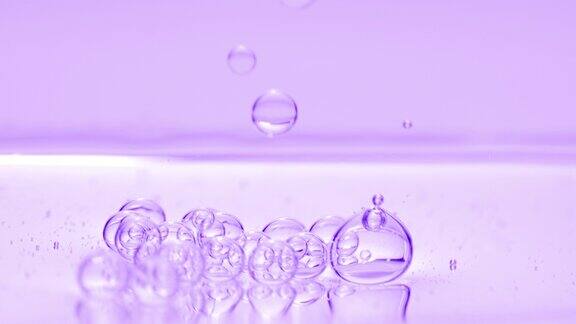 紫色气泡下沉到紫色背景的液体表面