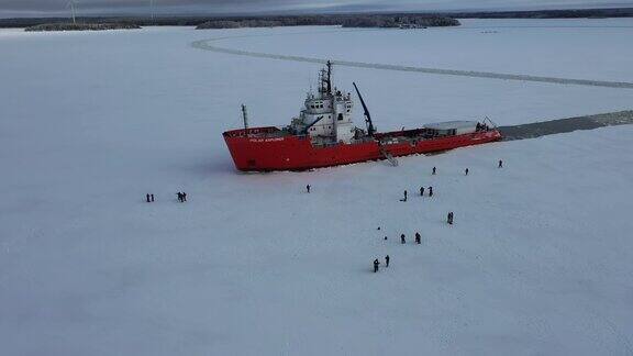 航拍的破冰船上人们在冰面上行走