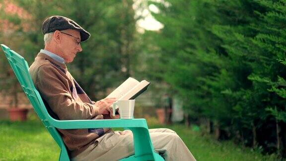 老人坐在塑料椅子上在户外看书