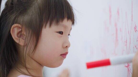 亚洲小女孩喜欢在客厅的白墙上作画可爱的小朋友们在家里愉快地画画、涂色享受着节日的创意活动