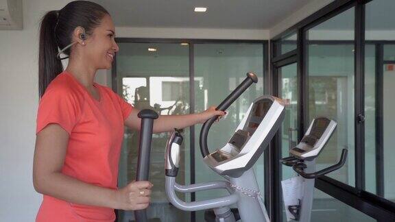 年轻女子在酒店健身房骑室内自行车锻炼