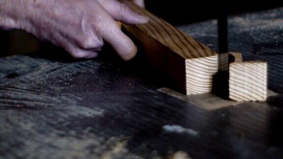 木匠用带锯仔细地锯一块木头