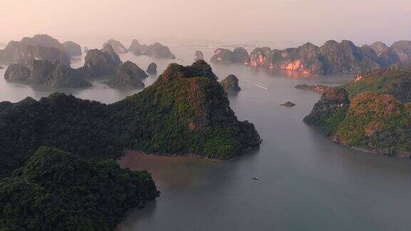 空中飞行:日落时独特的飞越下龙湾和吉巴岛这是越南著名的旅游目的地风景优美天空白云密布石灰岩山峰耸立于大海的地平线上