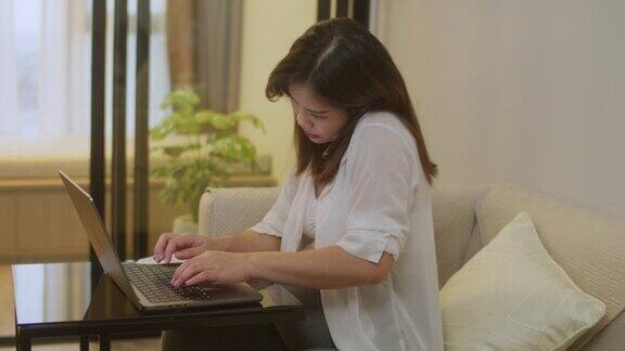亚洲孕妇在家用笔记本电脑工作