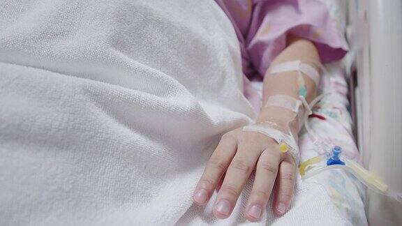 病人妇女的手在病床上休息和恢复与静脉滴注躺在病床上健康诊所保健