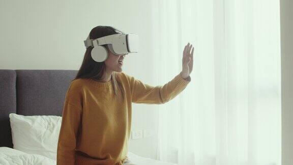 Metaverse使用虚拟现实头盔或VR眼镜的亚洲女性向她的朋友打招呼