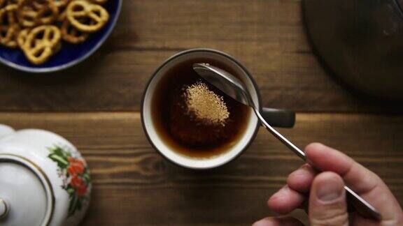 将蔗糖从勺子中倒入茶中