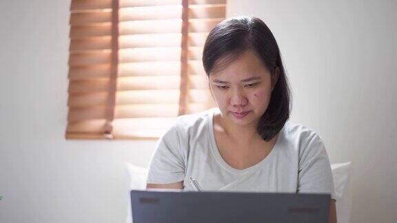 女性在家通过笔记本电脑在线教育自学