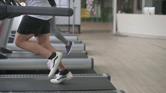 低段亚洲华人运动员在健身房跑步机上跑步