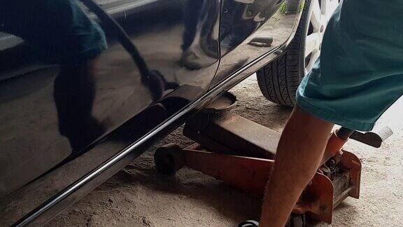 机械师汽车车间带千斤顶的液压升降车检查轮胎的保养和修理