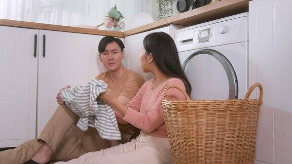 亚洲年轻夫妇一起洗衣服感觉很累