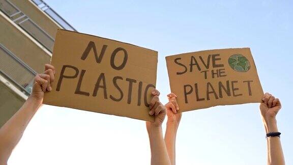 女性手举海报拯救地球和没有塑料以湛蓝的天空为背景