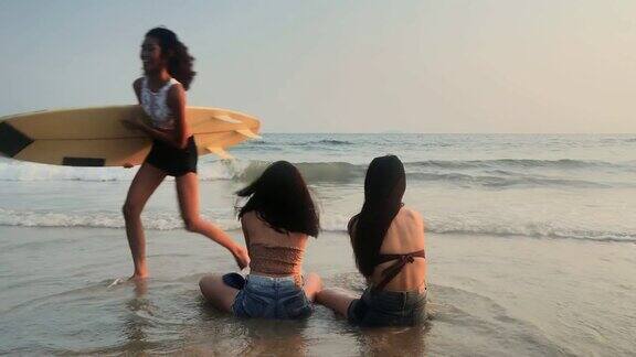 亚洲三个年轻的女性朋友有乐趣在日落海滩海滩度假旅游概念cinemagraph旅行