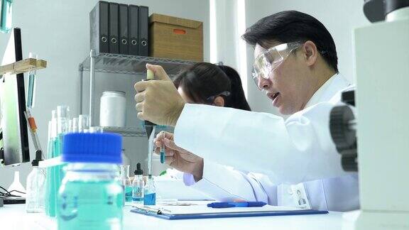 亚洲药剂师正在试验化学化合物并在试管中吸收液体制药、科学、测试开发和实验室产业的理念