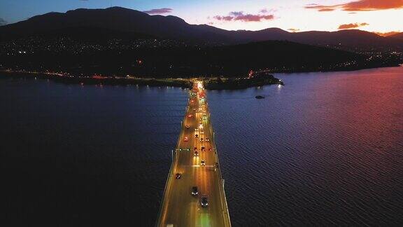 鸟瞰夜间横跨岛屿的桥梁交通