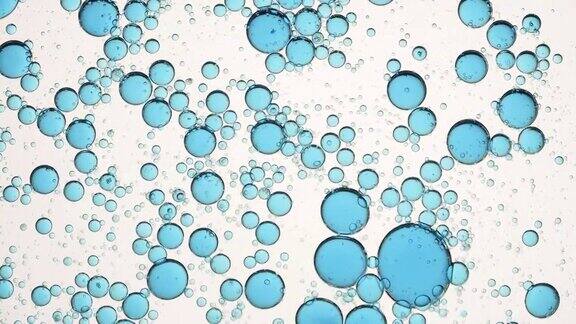不同大小的蓝色气泡在透明液体中绕圈移动
